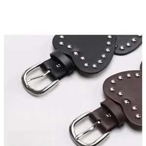 Close-up of vintage heart rivet belts in black and brown leather with D-shape metal buckle