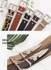 Detailed close-up of retro silver engraved buckle and tip on assorted fashion waist belts