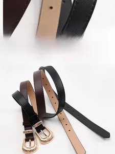 Detail of vintage thin belts with gold metal buckle and stitching on black and brown leather