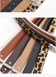 Detailed macro view of western retro carved silver buckles and various leather belt textures