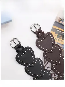 Detail of vintage heart-shaped rivet belt with silver studs in black and brown leather