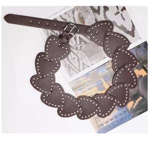 Detail view of heart shaped leather modules and silver rivets on the brown belt
