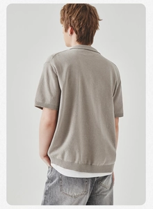 Dettaglio polo in maglia color avena con polsini a costine e vista posteriore minimalista