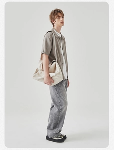 Polo in maglia beige da uomo abbinata a t-shirt bianca e borsa a tracolla in pelle