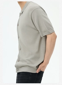 Dettaglio polo in maglia a maniche corte grigio chiaro con texture pregiata e polsini