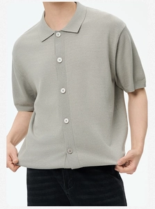 Dettaglio di polo in maglia grigio chiaro con abbottonatura e rifiniture a costine testurizzate