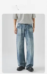Dettaglio dei jeans in denim lavato azzurro con baffi di gatto e texture vintage invecchiata
