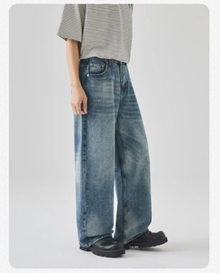 Vista laterale dei jeans a gamba larga blu lavaggio vintage con dettagli consumati