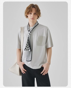 Close-up of light grey crew neck t-shirt with chest pocket and stylish houndstooth scarf