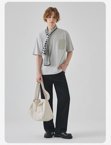 Minimalist summer outfit detail featuring a light grey crewneck t-shirt and hobo tote bag