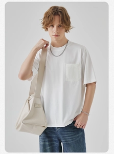 Close-up detail of white cotton t-shirt featuring a textured chest pocket and crew neck