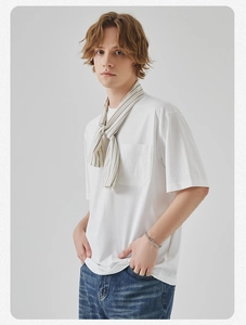 Detail of white cotton T-shirt featuring a front pocket and striped knit shawl