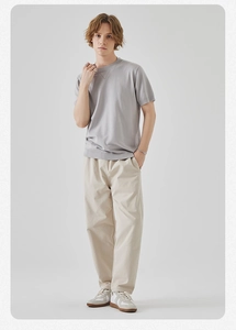 Dettaglio maglietta a maglia grigio chiaro con scollo a V e pantaloni casual beige