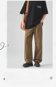 Detail of khaki cotton utility trousers featuring knee stitch seams and a straight fit