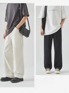 Detail of loose fit cotton cargo pants with knee seam stitching in black and off-white