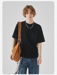 Detail of men's black crew neck t-shirt featuring a chest pocket and minimalist casual style