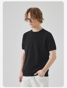 Dettaglio della maglietta nera in maglia slim-fit con girocollo a coste e cucitura decorativa