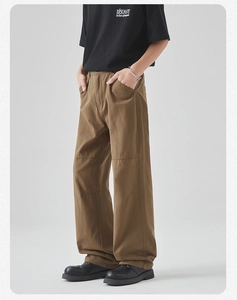 Detail of men's brown cotton cargo pants with knee stitching and straight leg fit