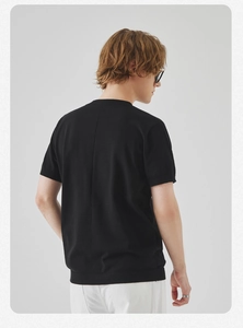 Dettaglio di una t-shirt in maglia nera da uomo con cucitura verticale sulla schiena