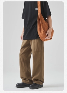 Detailed view of brown cotton cargo pants with visible seams and stylish oversized crossbody bag