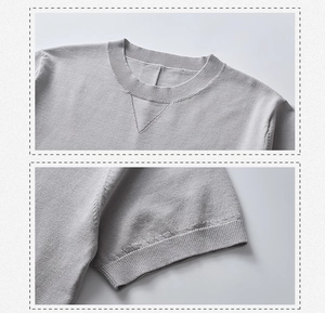 Dettaglio della cucitura a V sul collo e polsini a coste su t-shirt in maglia grigia uomo