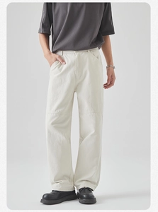Detail view of cream cotton cargo pants featuring knee panel stitching and a relaxed fit