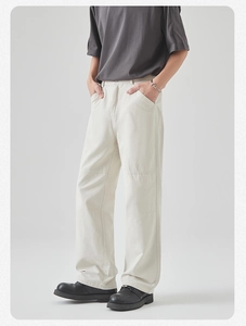 Close-up detail of beige cotton cargo trousers with straight cut and knee seam accents