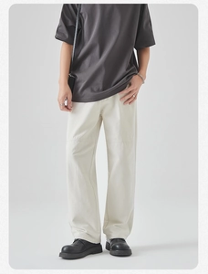 Detail of off-white cotton cargo pants with visible knee stitching and straight-leg fit