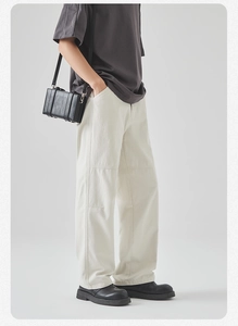 Detail view of men's wide-leg cotton cargo pants with a minimalist dark grey t-shirt style