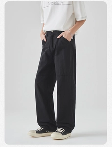 Detail of black cotton cargo pants showing utility pockets and stitching on wide leg cut
