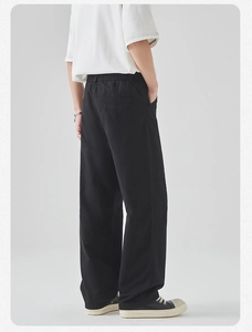 Rear view of men's black straight-leg cotton trousers with elastic waist and pockets