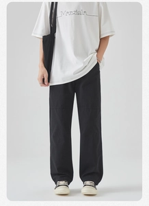 Detail of loose fit black cotton cargo pants paired with a white casual t-shirt