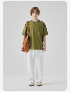 Full view of olive green oversized t-shirt with white trousers and brown bag