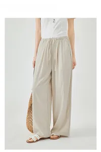 Detail of high-waisted wide-leg linen trousers with drawstring waist and side pockets