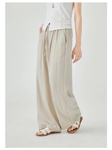 Detail view of khaki wide-leg pants featuring drawstring waist and pleated linen texture