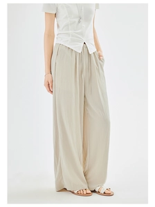 Detailed macro view of the loose high waist drawstring pants and soft drape texture