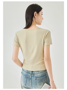 Detail of slim-fit beige T-shirt paired with denim jeans featuring gold P embroidery