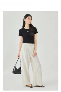 T-shirt nera sfiancata e pantaloni a gamba larga color crema con cintura e fibbia argento