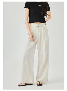 Dettaglio dei pantaloni a gamba larga color crema a vita alta con cintura e tessuto a pieghe