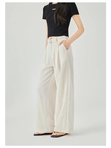 Dettaglio dei pantaloni a gamba larga a vita alta beige con cintura e trama del tessuto