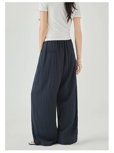 Detail view of the back of high-waisted navy wide-leg trousers with two welt pockets