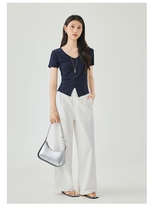 Detail of slim fit navy V-neck t-shirt and white high waist wide leg trousers
