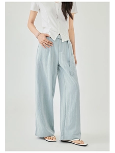 Dettaglio dei pantaloni a gamba larga celeste in lino con vita alta e cintura coordinata