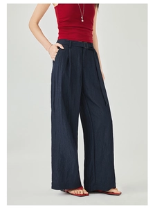 Dettaglio dei pantaloni blu navy a vita alta con cintura coordinata e fibbia quadrata