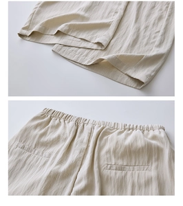 Detail view of the elastic waistband and fine stitching on light beige casual linen trousers