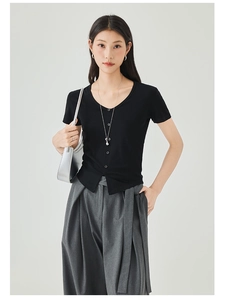 Detail of slim-fit black V-neck knitted top with buttons and stylish silver handbag
