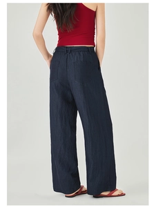 Dettaglio dei pantaloni larghi blu navy a vita alta con tasche posteriori ed elastico