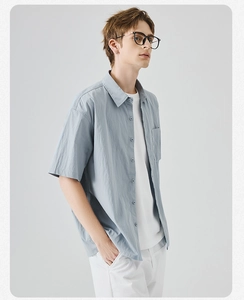 Dettaglio camicia azzurra a maniche corte con trama naturale e stile casual workwear