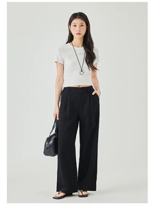Dettaglio dei pantaloni a gamba larga a vita alta con cintura e t-shirt bianca slim