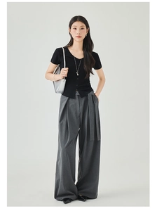 Detail of slim-fit black V-neck short sleeve knit top and high-waisted grey wide-leg trousers